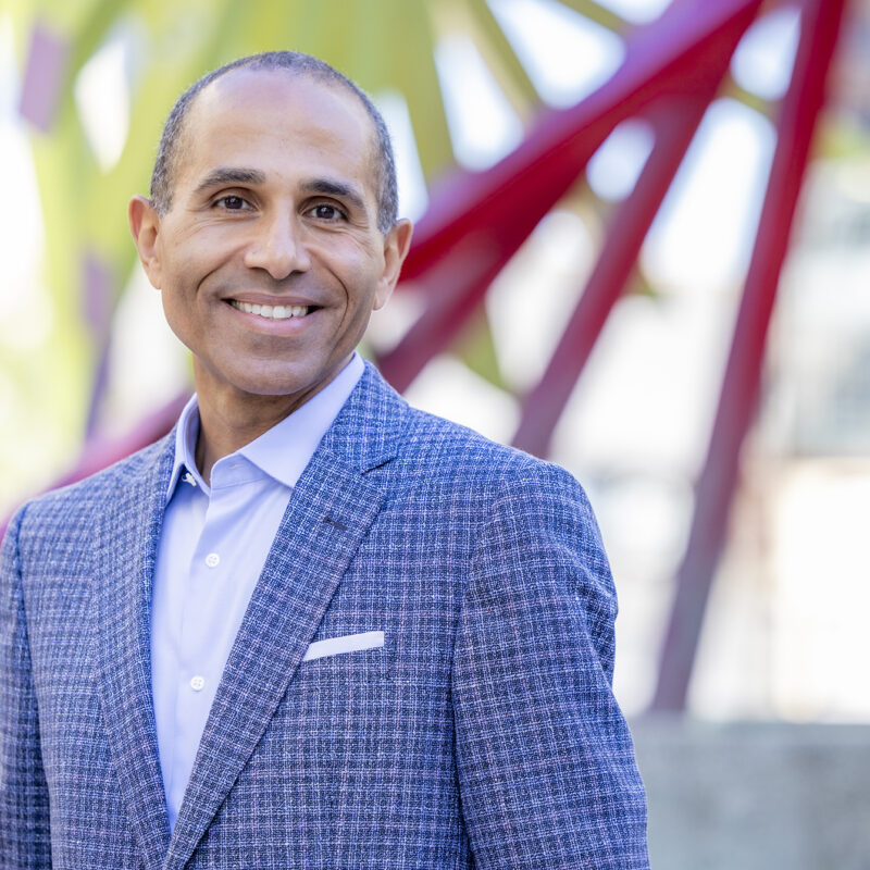 Man smiles at camera in outdoor setting